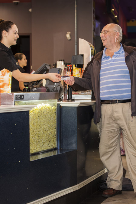 A man uses his Companion Card at a movie theatre.