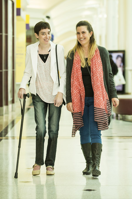 Two young women walk through a shopping centre.