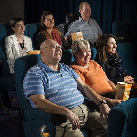 A group of people watching a movie at a theatre.